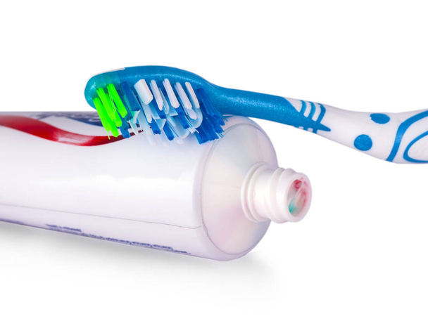 Beyaz arka plan üzerinde renkli diş fırçası diş ile yapıştırmak - Fotoğraf, Görsel