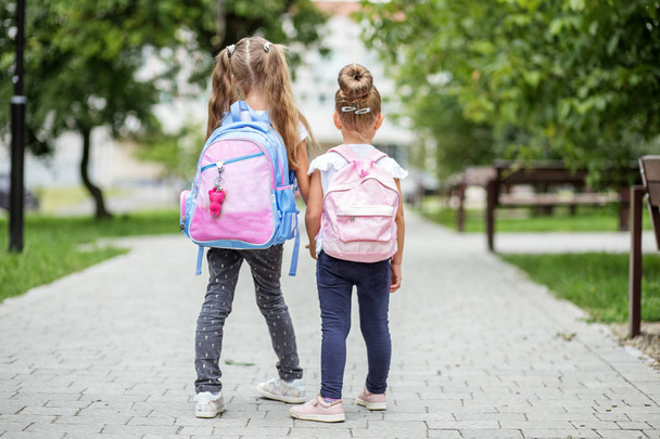 İki çocuk okul sırt çantaları ile gidin. Okul, eğitim, eğitim, dostluk, çocukluk kavramı - Fotoğraf, Görsel