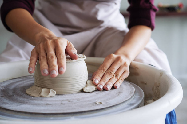 woman making craft work cup, partial view of hands creating clay pot - Фото, зображення