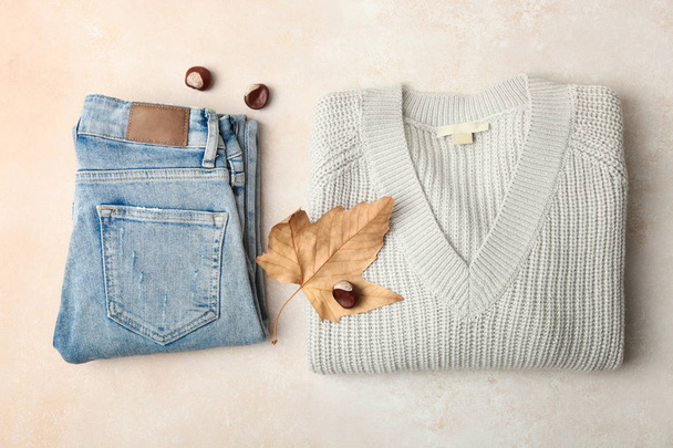 Warm sweater and jeans on neutral background. Concept autumn clothes. - Photo, Image
