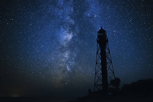 Silhouetten des alten Leuchtturms Sandstrand und Meer vor dem Hintergrund des Sternenhimmels. - Foto, Bild