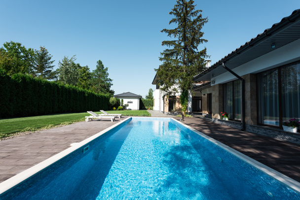 vue sur maison moderne, piscine avec chaises longues
  - Photo, image
