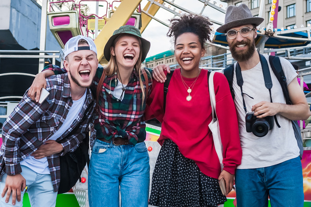 felices jóvenes amigos multiétnicos de pie juntos y riendo en el parque de atracciones
  - Foto, Imagen