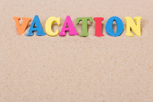 Vacaciones de palabras de letras de madera de colores en arena
 - Foto, Imagen