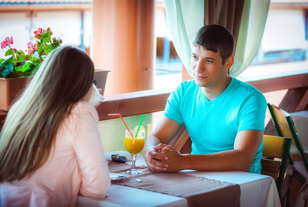 young happy couple sitting at table in cafe - Foto, Bild