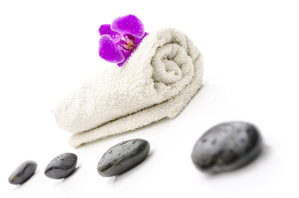 Pierres de massage et fleur d'orchidée violette sur une serviette
 - Photo, image