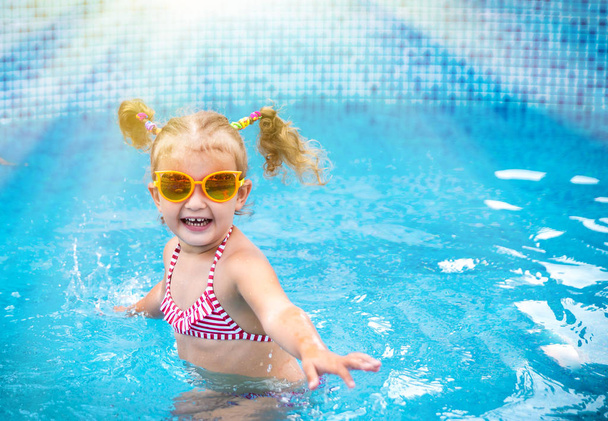 Little beautiful girl having fun  in the pool  - 写真・画像