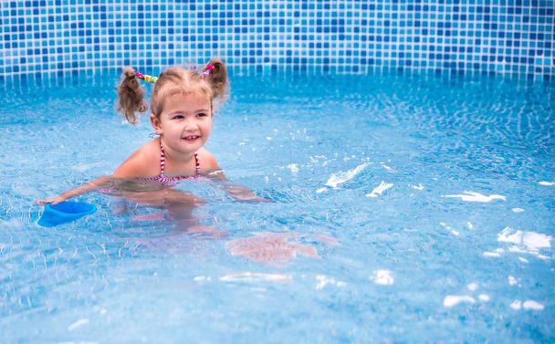 Little beautiful girl having fun  in the pool  - Foto, Imagen