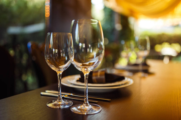 Šumivé skleněné nádobí stojí na dlouhém stole připraveném na svatební večeři. - Fotografie, Obrázek