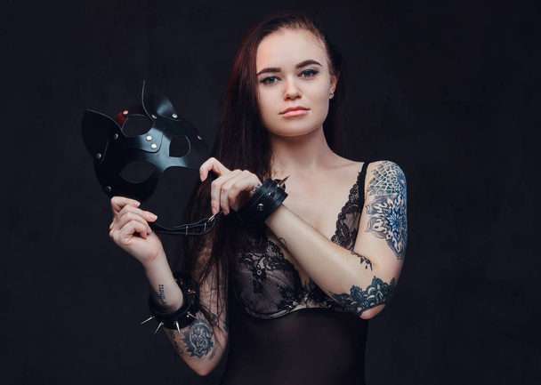 Bdsm macska bőr maszk és kiegészítők pózol a sötét háttér előtt fekete fehérnemű fárasztó szexi nő.  - Fotó, kép