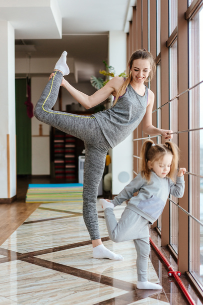 Mom and daughter together perform different exercises - Foto, imagen