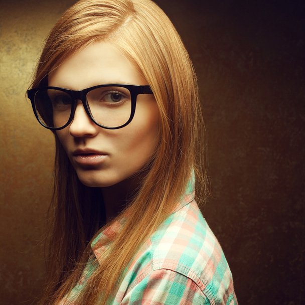 Portrait of a young beautiful red-haired wearing trendy glasses - 写真・画像