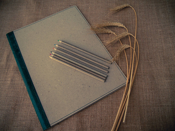Vintage tarzı. Binder, kalemler ve kuru buğday ve çuval bezi arka plan ile organize masası - Fotoğraf, Görsel