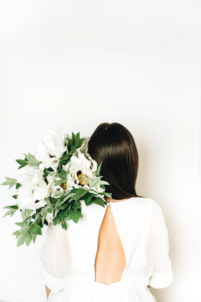 woman holding white peony flowers bouquet on white background - Zdjęcie, obraz