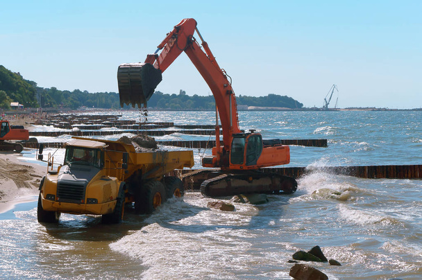 Baumaschinen an der Küste, der Bau von Buhnen, Maßnahmen zum Küstenschutz - Foto, Bild