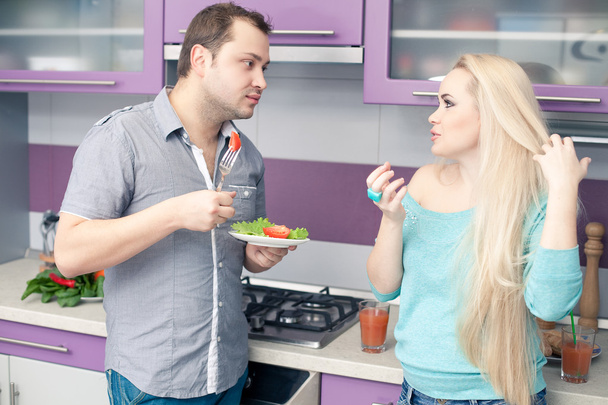 Portrait of a cute young couple eating fresh vegetable salad at - Photo, image
