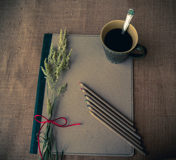 Vintage tarzı. Bağlayıcı, bir fincan kahve, Kuru ot, kalemler ve çuval bezi arka plan ile organize masası - Fotoğraf, Görsel