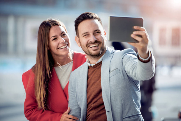 Boldog fiatal pár figyelembe selfie a városban. Életmód, a pár, a szeretet és a móka a koncepció. - Fotó, kép