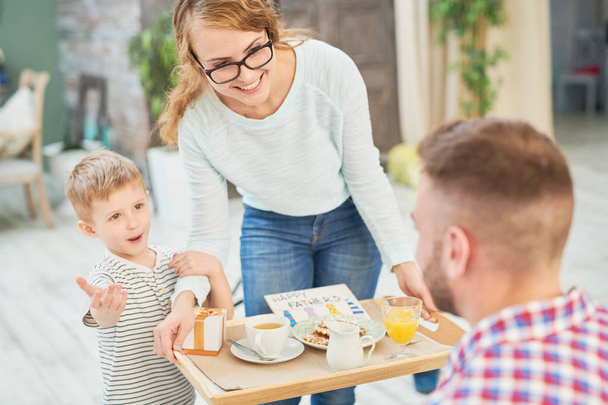 Теплий тоновані портрет з дружиною і сином приведення сюрприз сніданок для тата святкує день батьків вдома - Фото, зображення