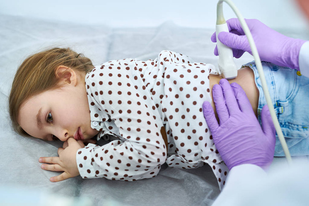 Oříznout pohled lékaře kontrola zadní dítě leží žaludku na lékařské gauči - Fotografie, Obrázek