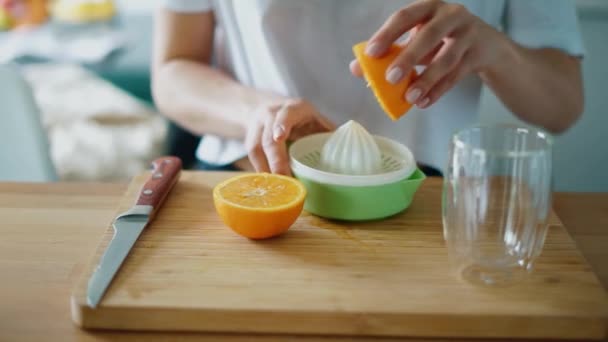 Nainen kädet puristamalla tuoretta appelsiinimehua sitrushedelmien puristimella
 - Materiaali, video