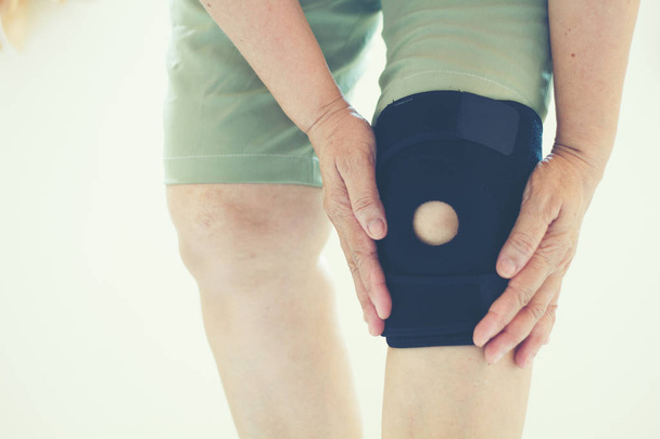 Розмитий фокус старі азіатських жінок на травму коліна на білому тлі - Фото, зображення