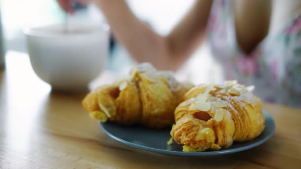 Tradiční snídaně s kávou a francouzské croissanty. Servírované kuchyňský stůl - Záběry, video