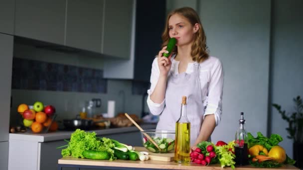 Fiatal lány gondolkodás uborka evés közben. Szomorú nő eszik a healty diéta élelmiszer - Felvétel, videó