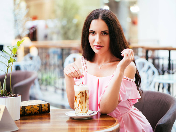 Onnellinen nuori nainen istuu kahvilassa ottaa levätä ostosten jälkeen
 - Valokuva, kuva
