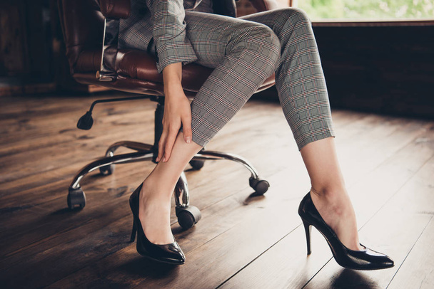 Close-up cropped classic stylish business ladys graceful legs in black classic elegant shoes and grey suit, hand touching smooth soft skin after epilation depilation - Foto, Imagem