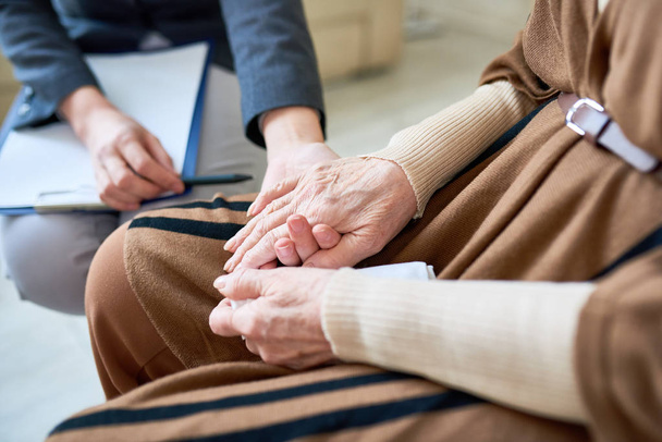 Nahaufnahme einer Psychologin, die während einer Therapiesitzung die Hand einer älteren Patientin hält, Kopierraum - Foto, Bild