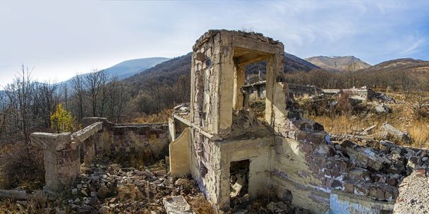 Paisaje apocalíptico con edificio destruido en un páramo con montañas en el fondo. Devastación y concepto de guerra
 - Foto, imagen