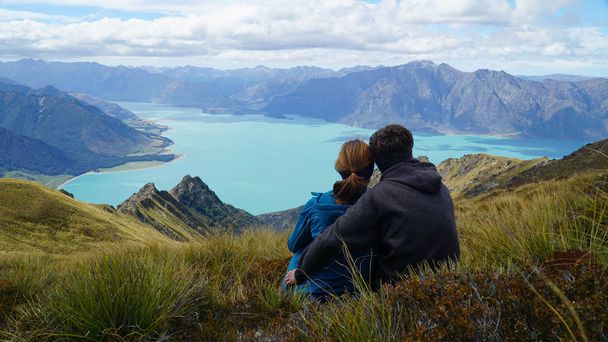 Couple enjoying a view of lake Hawea from Isthmus Peak, New Zealand - Photo, Image