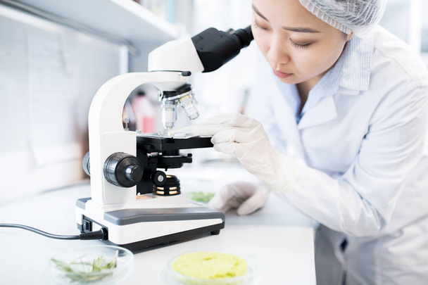 Side view portret azjatyckich kobiet naukowców za pomocą mikroskopu podczas prowadzenia badań w laboratorium medyczne - Zdjęcie, obraz