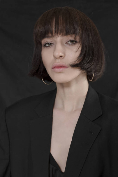 Beautiful, stylish girl in fashionable black clothes with short black hair. Fashionable studio shot - Fotoğraf, Görsel