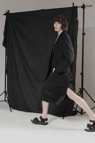 Beautiful, stylish girl in fashionable black clothes with short black hair. Fashionable studio shot - Foto, afbeelding
