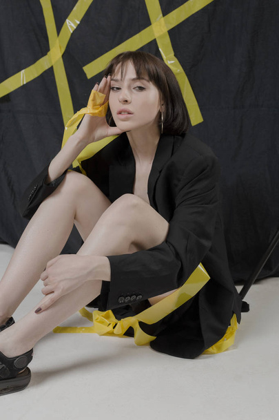 Beautiful, stylish girl in fashionable black clothes with short black hair. Fashionable studio shot - Photo, Image