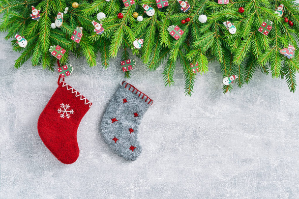Christmas fir tree and Christmas socks on gray background. Copy space, top view. Christmas background - Photo, Image