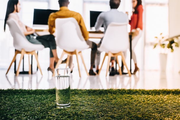 селективный фокус стекло воды и мультиэтнических бизнесменов, сидящих за столом в офисе
 - Фото, изображение