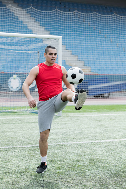 Ολόσωμο πορτρέτο του όμορφος νεαρός άνδρας, παίζοντας ποδόσφαιρο στο υπαίθριο γήπεδο αντίγραφο χώρου - Φωτογραφία, εικόνα