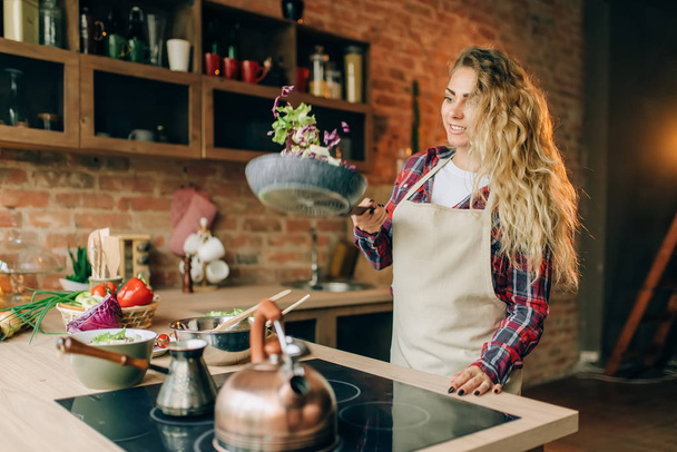 主婦エプロン キッチン インテリアの背景に、パンで野菜を揚げます。健康的なベジタリアン料理、野菜の準備を作る女性のクック - 写真・画像