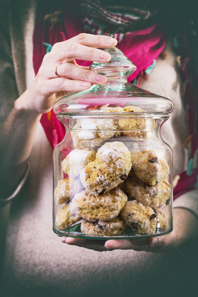 The girl is holding in a glass jar the italian orange-chocolate cooki - Foto, Imagem