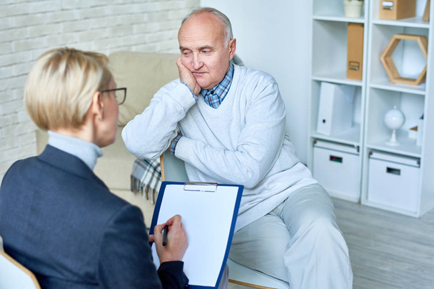 Retrato de un hombre mayor calvo hablando con una terapeuta durante la consulta, espacio para copiar
 - Foto, imagen
