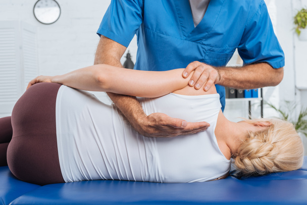 plan recadré de chiropraticien massant dos du patient qui se trouve sur la table de massage à l'hôpital
 - Photo, image