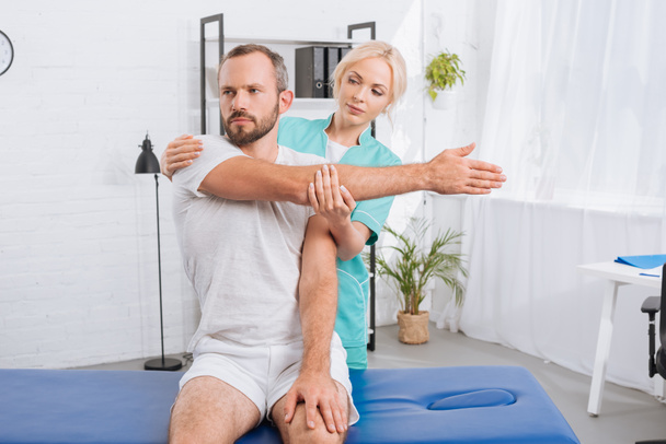 portrait de physiothérapeute étirant bras mans à l'hôpital
 - Photo, image