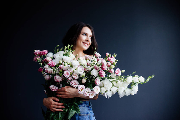 Beautiful girl with a bouquet flowers. - Foto, imagen