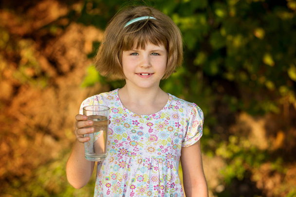 Pikkutyttö vesilasillisen kanssa aamulla, juo joka päivä. Terveellisten elämäntapojen käsite
 - Valokuva, kuva