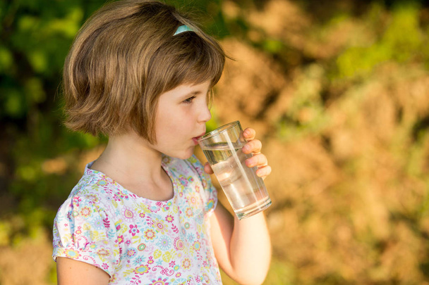 Little girl kid with glass of water in morning, drink every day. Concept of healthy habits - Photo, Image