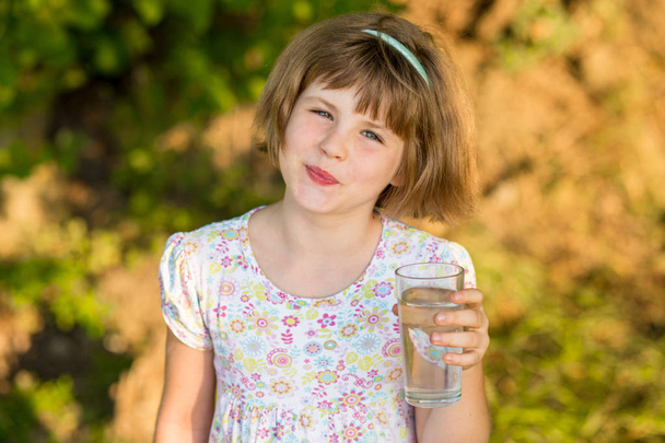 Little girl kid with glass of water in morning, drink every day. Concept of healthy habits - Photo, Image