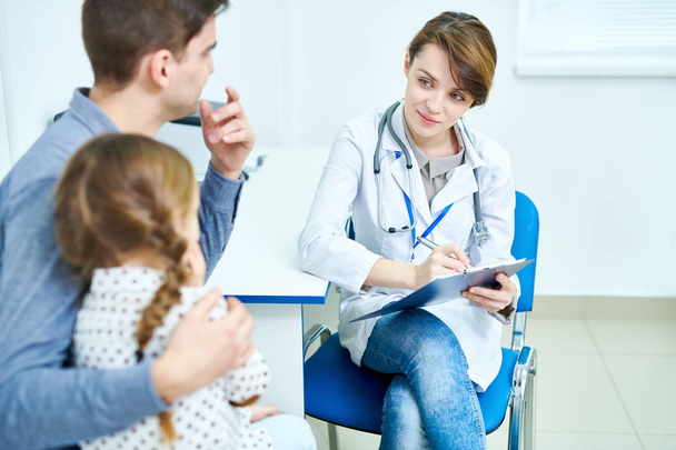 Προβολή περικοπή της γυναικείας γιατρός κάθεται στο γραφείο και ακούγοντας μικρός ασθενής - Φωτογραφία, εικόνα